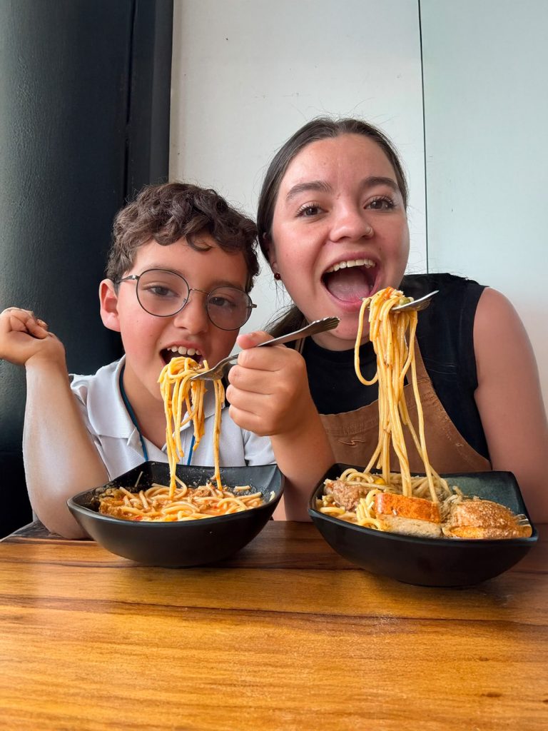Manuela Gómez Gómez, chef y propietaria de Manuelina, comparte un plato de pasta con su hijo en Manizales.